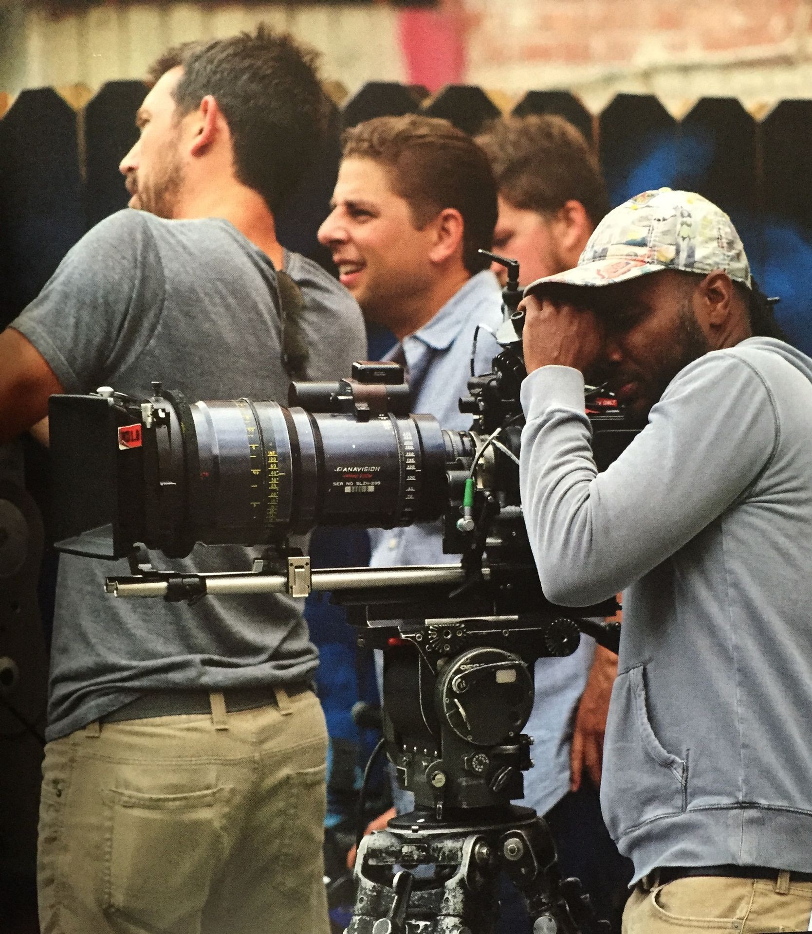 Camera crew adjusting professional filming equipment outdoors.